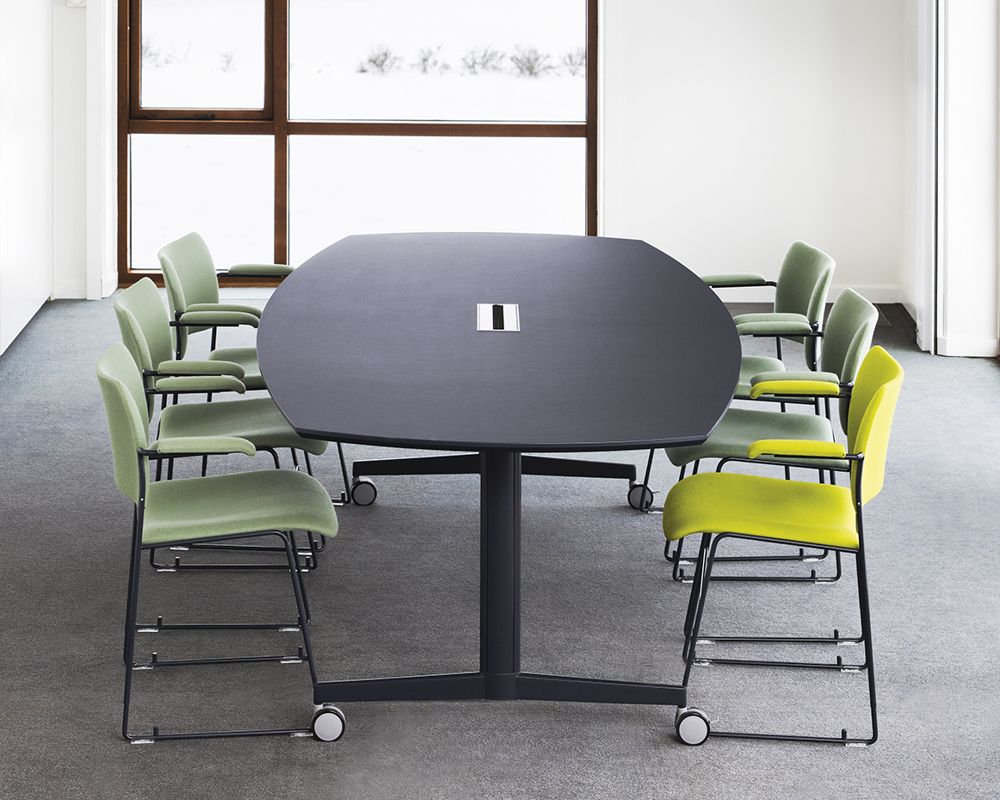 A black Moveo table and green 40/4 chairs in a room