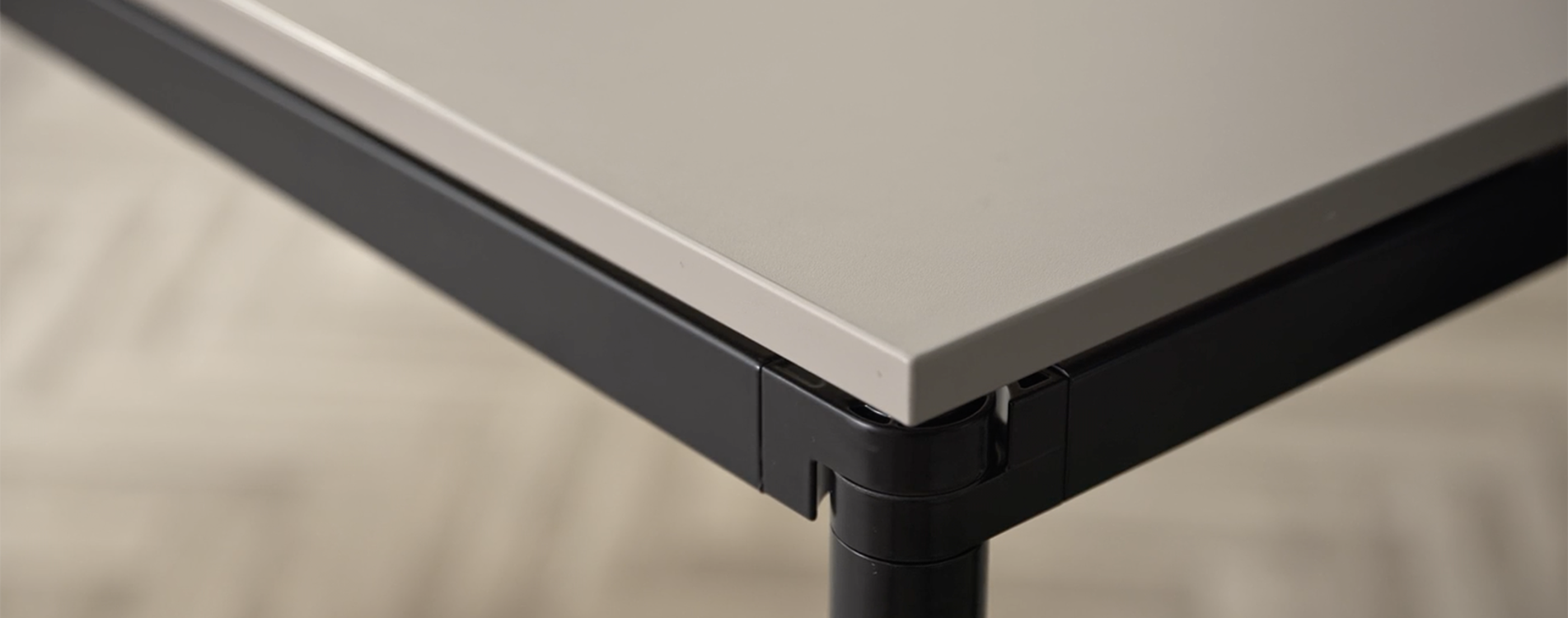 A detailed image of a Simpla table with a black frame and brownish tabletop 