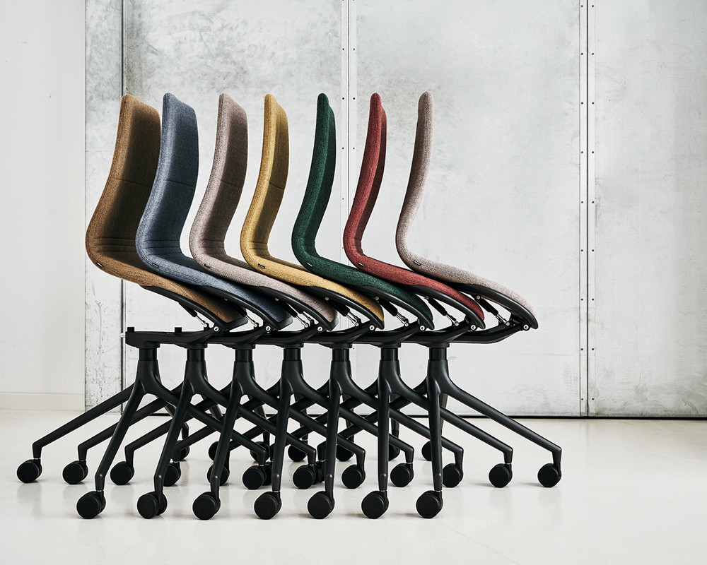 A group of nested AS100 chairs in front of a white wall