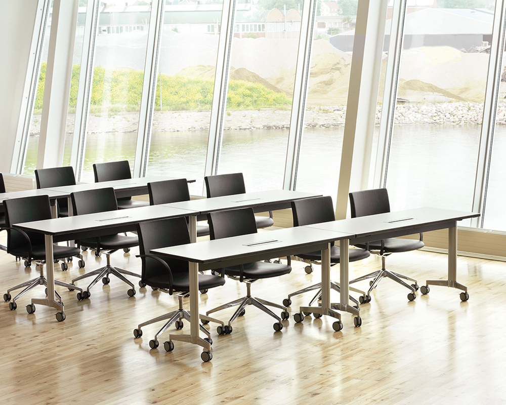 A classroom setting with Moveo training tables and black chairs on wheels