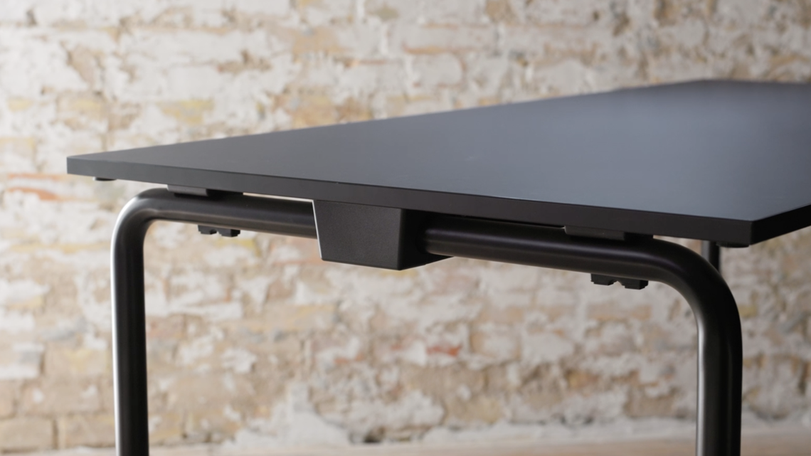 A close-up image of the black Usu table against a brick wall