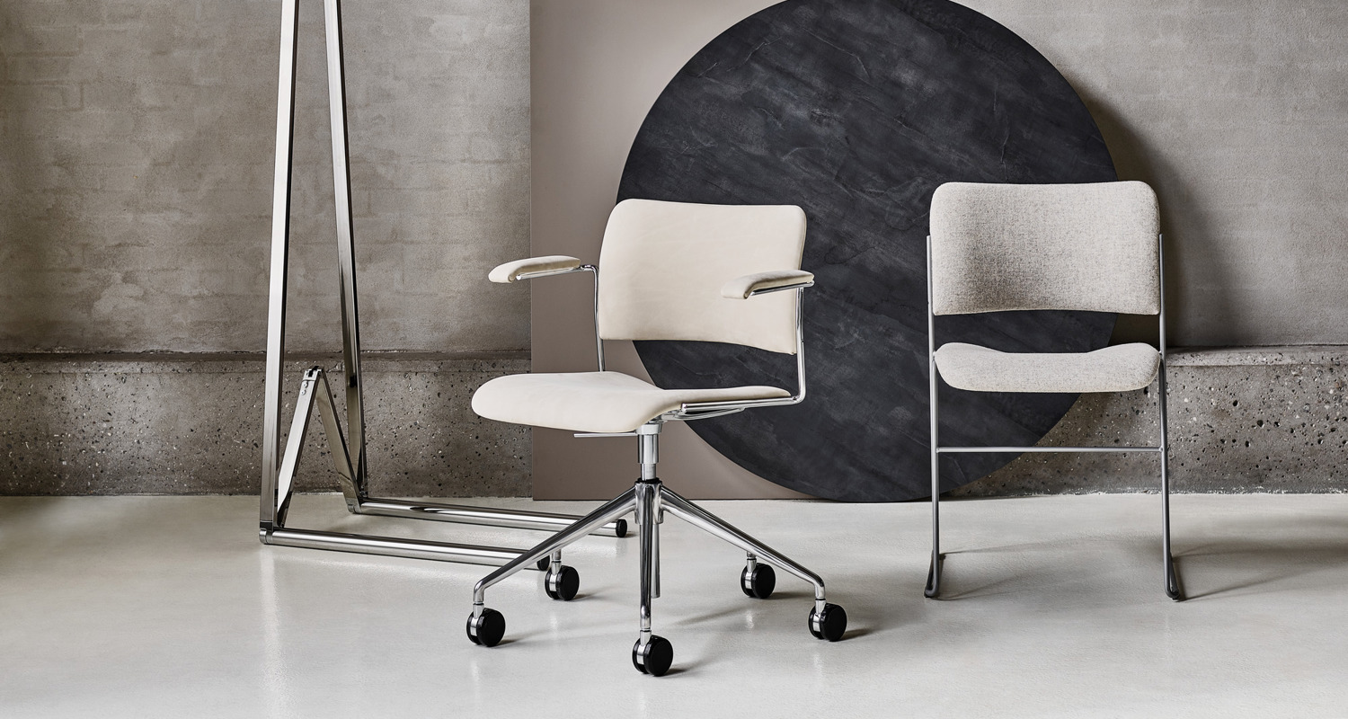 An installation image with 40/4 chairs arranged in front and table tops in the background
