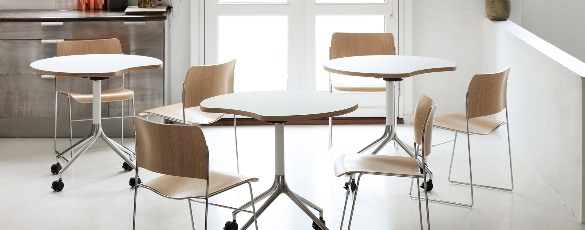 A group of 40/4 veneer chairs and AS400 white tables in a kitchen/canteen area