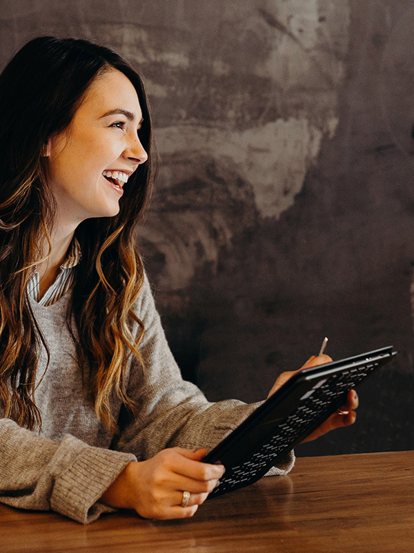 A smiling person with a tablet 